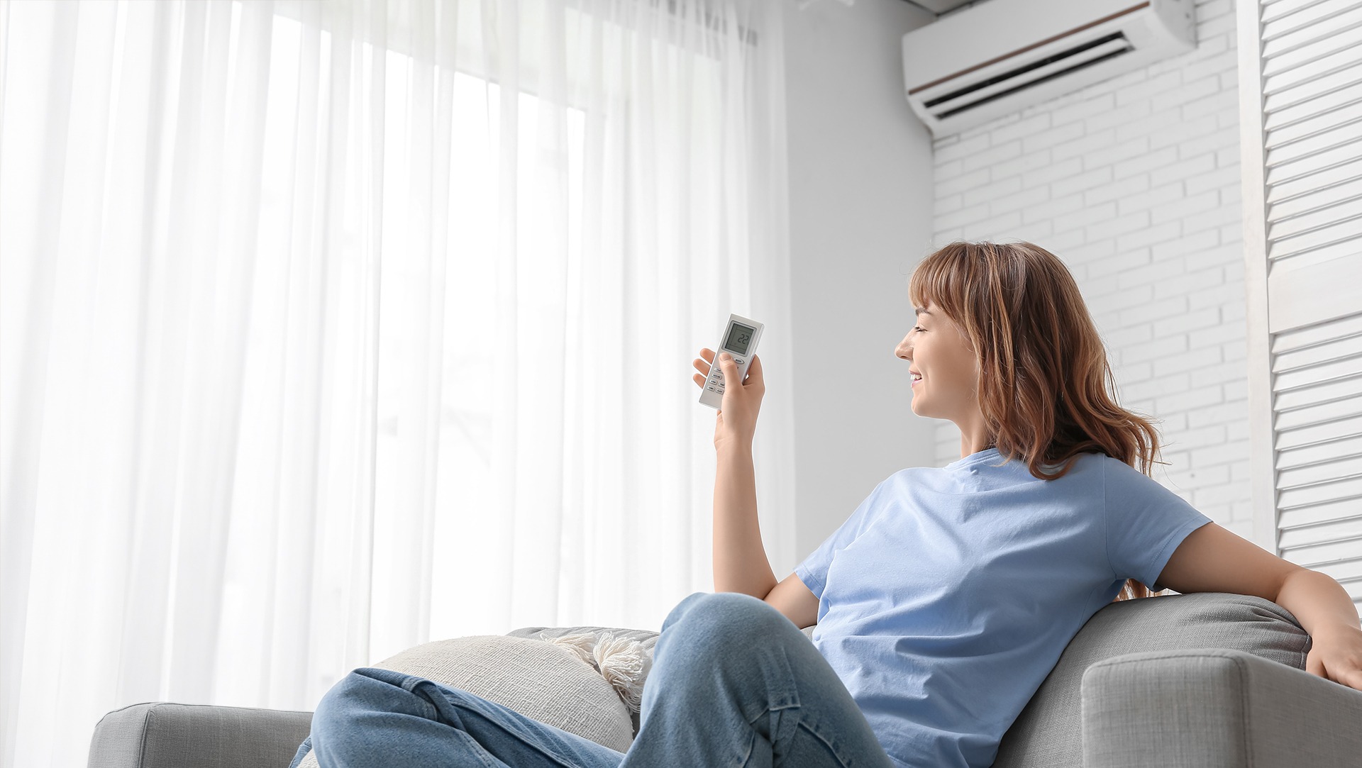 photo femme dans son salon allume la climatisation