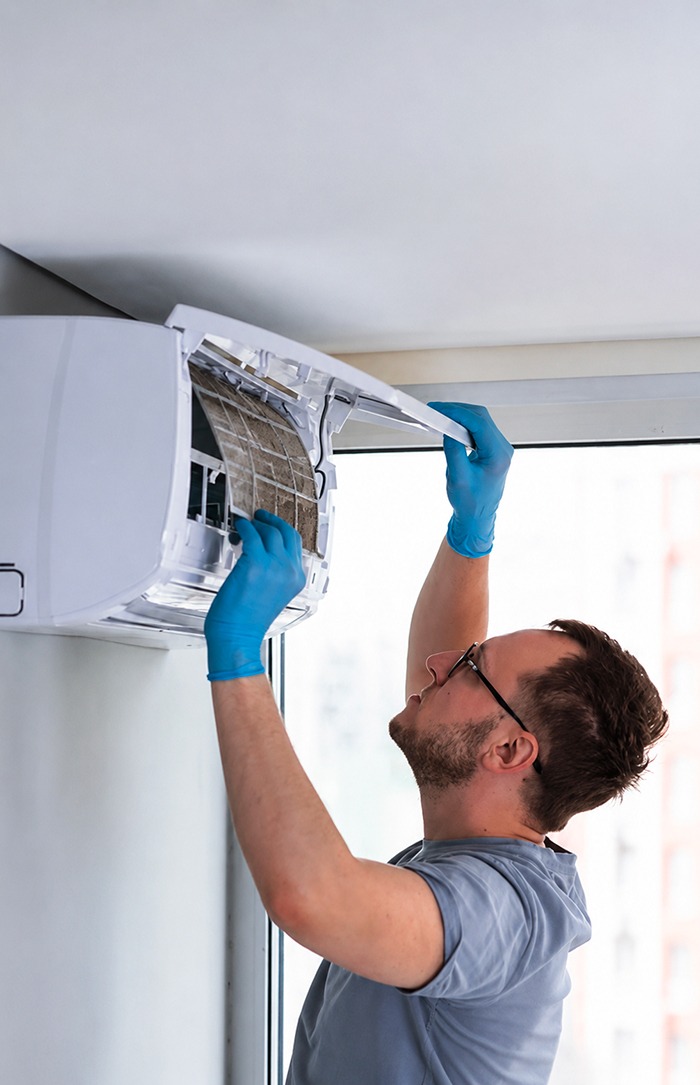 technicien inspecte une unite de climatisation